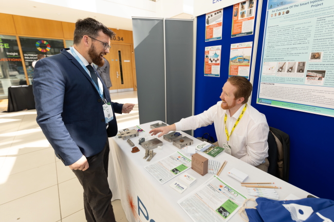 Two people talking at an exhibition stand